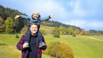 Vater und Sohn wandern durch die herrliche Herbstlandschaft des Erzgebirges. Urlaub im Familienhotel Elldus Resort.