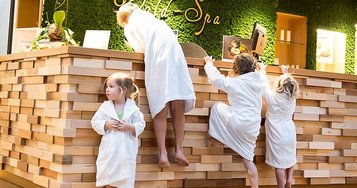 Kinder stehen an der Rezeption im hoteleigenen Wellnessbereich des Familienhotels Ulrichshof im Bayerischen Wald. Der Wellnessbereich bietet auch für Kinder einige Angebote an.