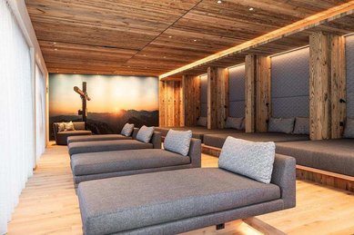 Ruheraum im Wellnessbereich des Familienhotels Oberkarteis im Salzburger Land mit mehreren Liegen und Holzdetails.