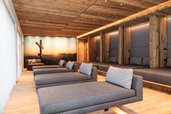 Ruheraum im Wellnessbereich des Familienhotels Oberkarteis im Salzburger Land mit mehreren Liegen und Holzdetails.