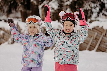 Zwei Mädchen die sich auf Ski fahren freuen.
