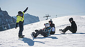 Familienhotel Alpenhof Dolomit Family im Winter perfekt an den schönsten Pisten gelegen. Eine Gruppe Teenager hat sich zum gemeinsamen Snowboard fahren getroffen.