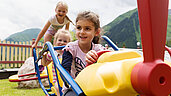 Kinder spielen auf dem Spielplatz vom Familienhotel Kaiserhof an der Tiroler Zugspitzarena.