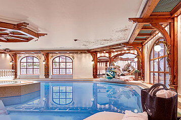 Indoor Schwimmbad im Familienhotel Tirolerhof an der ZUgspitze mit einer schönen Aussicht durch die großen Fenster.