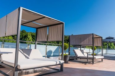 Moderne Daybeds mit Sonnenschutz auf der Dachterrasse vom Familienhotel Friedrichshof.