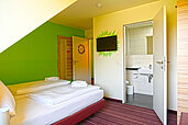 Zimmer mit Doppelbett und direktem Zugang zum Badezimmer im Familienhotel Rhön Feeling.