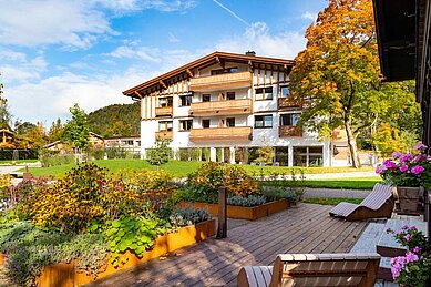 Außenansicht vom Familienhotel Das Bayrischzell mit Parkanlage und Gartengestaltung.