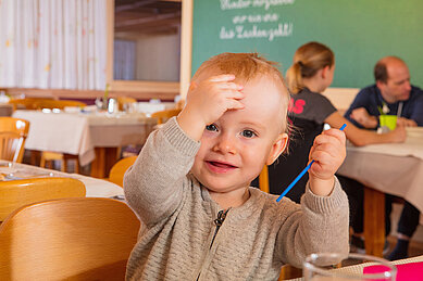 Ein Kleinkind im Restaurant im Familienhotel Sonne Bezau Vorarlberg.