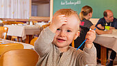 Ein Kleinkind im Restaurant im Familienhotel Sonne Bezau Vorarlberg.