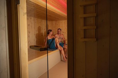Paar genießt wohltuende Wärme in der Zirbensauna des Familienhotels Krone im Allgäu.