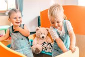 Kleinkinder spielen lachend im Wichtelclub des Familienhotel Friedrichshof.