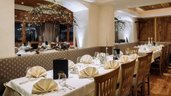 Gedeckter Tisch mit Kerzen im Restaurant im Adler Familien- & Wohlfühlhotel in Tirol.