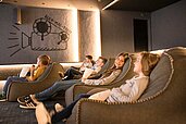Kinder und Teens schauen im hoteleigenen Kino des Allgäuer Berghofs einen Film.