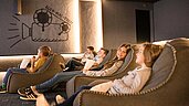 Kinder und Teens schauen im hoteleigenen Kino des Allgäuer Berghofs einen Film.