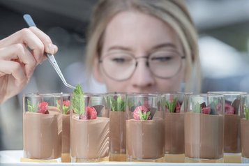 Köchen richtet Dessert im Glas an im Familienhotel Gorfion