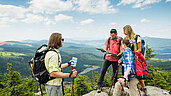 Eine Gruppe wandert in den Bergen am Arbersee im Bayerischen Wald.