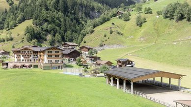 Sonnige Terrasse des Familienhotels Oberkarteis mit modernen Sitzbereichen und Blick auf die umliegenden Berge im Salzburger Land.