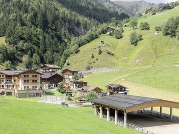 Sonnige Terrasse des Familienhotels Oberkarteis mit modernen Sitzbereichen und Blick auf die umliegenden Berge im Salzburger Land.