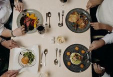 Eine Familie genießt gemeinsam ein Essen am gedeckten Tisch im Restaurant des Hotel Sonngastein im Salzburger Land.