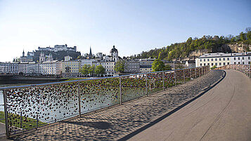 Salzburger Land Ausflugstipps: Im Hintergrund die Salzburger Festung Hohensalzburg und im Vordergrund eine Brücke mit vielen Liebesschlössern.