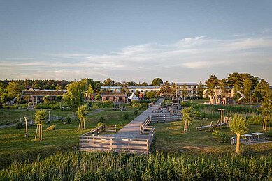 Außenansicht des Familienhotels Seeklause an der Ostsee. Das Familienhotel ist von einer großzügigen Außenanlage mit Pirateninsel für Kinder zum Spielen umgeben.