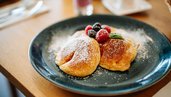 Frisch zubereitete Pancakes mit Beeren und Puderzucker im Familien Resort Petschnighof in Kärnten.