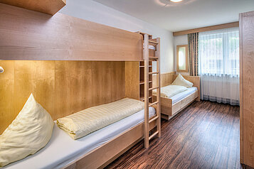 Kinderzimmer mit einem Hochbett und einem normalem Bett im Kinderhotel Stefan in Pitztal.