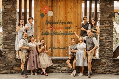 Die Gastgeberfamilie Walchhofer des Familienhotel Zauchenseehof im Salzburger Land - "Wir sind Fans von guter Laune und echten Glücksgefühlen" steht auf dem Schild