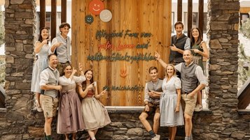 Die Gastgeberfamilie Walchhofer des Familienhotel Zauchenseehof im Salzburger Land - "Wir sind Fans von guter Laune und echten Glücksgefühlen" steht auf dem Schild