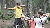 Urlaub mit Teens im Familienhotel Alpenhof Dolomit Family in Südtirol. Gemeinsam mit dem Teens-Club geht es in den Wald zum Bogenschießen. Unter Anleitung dürfen die Großen ihr Können beweisen.