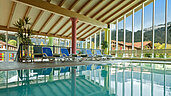 Schwimmbad mit Liegen und Panoramafenstern im Familienhotel Spa- & Familien-Resort Krone im Allgäu.