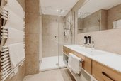 Modernes Badezimmer mit großer Dusche und Doppelwaschbecken im Familienhotel Habachklause.
