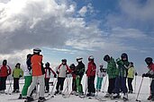 Eine Gruppe von Kinder lernt im Familienurlaub im Hotel Alpengasthof Hochegger Ski fahren.