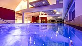 Beleuchteter Indoor-Pool im Wellnessbereich des Familienhotels Galtenberg Family & Wellness Resort.