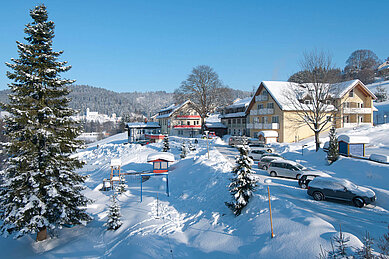 Das Familienhotel Mein Krug im Fichtelgebirge, umgeben von einer winterlichen, verschneiten Umgebung.