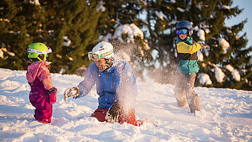 Familie bei einer Schneeschlacht im Familienurlaub im Schwarzwald.