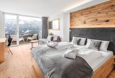 Große, helle Suite mit Couch und großem Doppelbett im Familienhotel Allgäuer Berghof.
