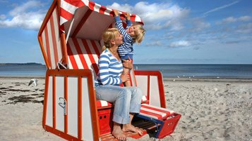 Mutter und Kind genießen die Sonne im Strandkorb an der Nordsee