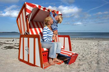 Mutter und Kind genießen die Sonne im Strandkorb an der Nordsee