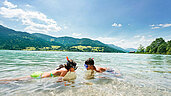 Zwei Kinder schnorcheln im See im Familienurlaub in Kärnten.