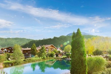 Außenansicht des Familienhotels Landgut Furtherwirt mit blumengeschmückten Balkonen und traditioneller Holzfassade.