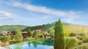 Außenansicht des Familienhotels Landgut Furtherwirt mit blumengeschmückten Balkonen und traditioneller Holzfassade.