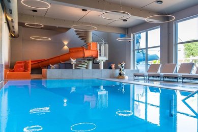 Die große Indoor-Wasserrutsche und der Poolbereich im Familienhotel Friedrichshof bieten Badespaß für Groß und Klein.