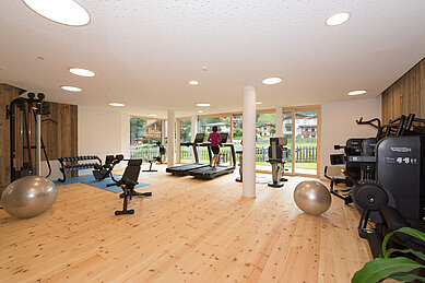 Großer Fitnessraum mit viel Tageslicht im Familienhotel Hotel Tirolerhof an der Zugspitze.