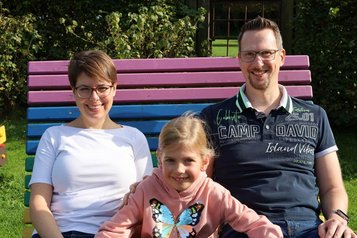 Eine Familie die im Familienhotel Monikas Ferienhof auf einer Bunten Back sitzt.