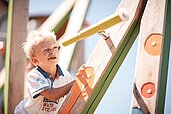 Ein Kind auf dem Kinderspielplatz im Family Home Alpenhof in Südtirol.