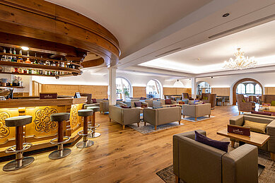 Gemütliche Bar mit Barhockern und und entspannten Sitzmöglichkeiten im Familienhotel Kaiserhof an der Zugspitze.