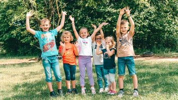 Glückliche Kinder beim gemeinsamen Spielen in der Natur am Familienhotel Friedrichshof.