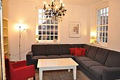 Aufenthaltsbereich für Familien mit Sofa und schönen Fenstern im Familienhotel Gut Landegge im Emsland.