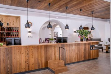 Die stilvolle Rezeption aus warmem Holz und modernen Akzenten im Landgut Furtherwirt lädt zum Einchecken und Wohlfühlen ein